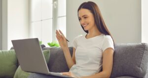 Das Bild zeigt eine junge Dame, die auf Ihre Körperspache im virtuellen Vorstellungsgespräch achtet